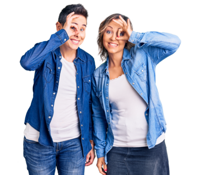 Couple of women wearing casual clothes doing ok gesture with hand smiling, eye looking through fingers with happy face.