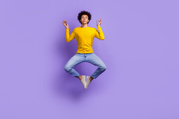 Full size photo of funny carefree guy dressed yellow long sleeve jeans levitating in meditation...