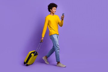 Full body photo of young student guy smartphone chatting with tour operator travel agency with baggage isolated on purple color background - obrazy, fototapety, plakaty