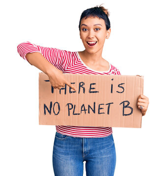 Young woman holding there is no planet b banner smiling happy pointing with hand and finger
