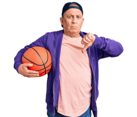 Senior handsome grey-haired man holding basketball ball with angry face, negative sign showing dislike with thumbs down, rejection concept