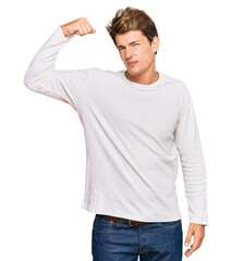Fototapeta premium Handsome caucasian man wearing casual white sweater strong person showing arm muscle, confident and proud of power