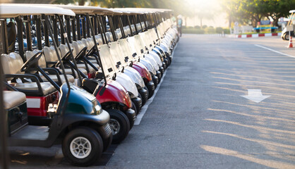 Many golf carts for golf player on a golf course. golf course carts cars at luxury resort sport venue in neat line row.