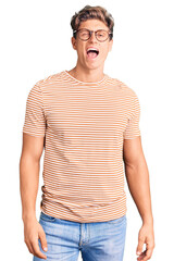 Fototapeta premium Young handsome man wearing casual clothes and glasses winking looking at the camera with sexy expression, cheerful and happy face.