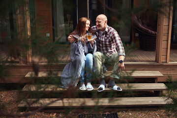 Male in love hugging happy woman on veranda