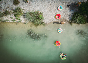 Image of family enjoying swimming in a river. Over head drone shot, colorful, fun, outdoors.