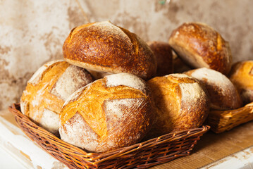 Delicious fresh breads in wicker baskets placed on wooden table