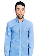 Hispanic man with beard wearing casual business shirt making fish face with lips, crazy and comical gesture. funny expression.