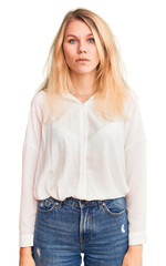 Young beautiful blonde woman wearing casual shirt with serious expression on face. simple and natural looking at the camera.
