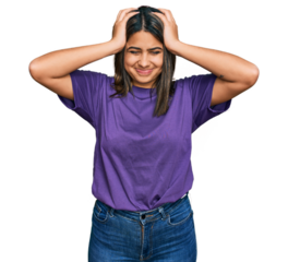 Young hispanic girl wearing casual purple t shirt suffering from headache desperate and stressed because pain and migraine. hands on head.