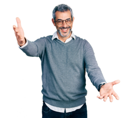 Middle age hispanic with grey hair wearing glasses looking at the camera smiling with open arms for hug. cheerful expression embracing happiness.