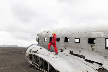 Walking girl on the old crashed plane abandoned on Solheimasandur beach near Vik in Iceland
