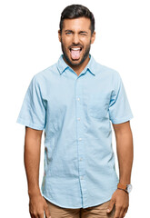 Obraz premium Handsome hispanic man wearing casual clothes sticking tongue out happy with funny expression. emotion concept.