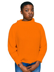 Fototapeta premium Young african american woman wearing casual clothes puffing cheeks with funny face. mouth inflated with air, crazy expression.