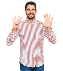 Young hispanic man wearing business shirt showing and pointing up with fingers number nine while...