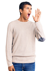 Young african amercian man wearing casual clothes shouting and screaming loud to side with hand on mouth. communication concept.