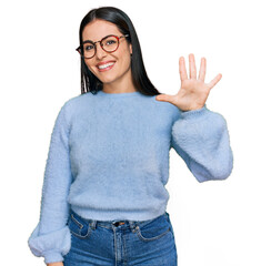 Young hispanic woman wearing casual clothes and glasses showing and pointing up with fingers number...