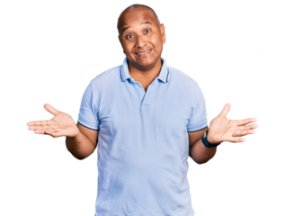 Hispanic middle age man wearing casual t shirt clueless and confused expression with arms and hands raised. doubt concept.