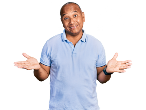Hispanic middle age man wearing casual t shirt clueless and confused expression with arms and hands raised. doubt concept.