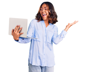 Young beautiful mixed race woman working using computer laptop celebrating victory with happy smile and winner expression with raised hands