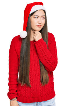 Young chinese woman wearing christmas hat touching painful neck, sore throat for flu, clod and infection