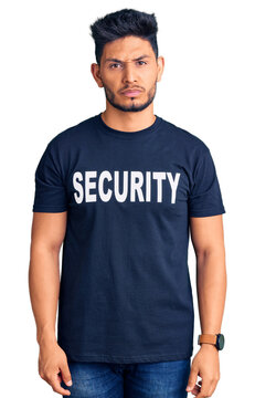 Handsome latin american young man wearing security t shirt skeptic and nervous, frowning upset because of problem. negative person.