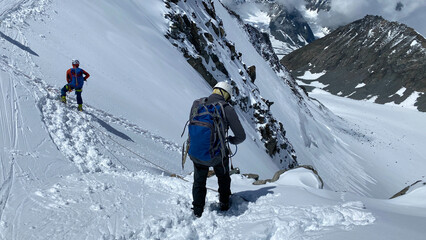 Two climbers are standing at the top of the Delaunay Pass. Climbing Belukha. Altai Mountains. View of mountain ranges
