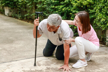 daughter or caregiver Helping to support an elderly man who fell on the concrete floor. Falling in...