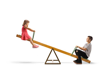 Little girl playing on a seesaw with an older boy
