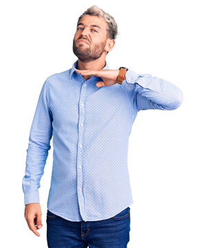 Young handsome blond man wearing elegant shirt cutting throat with hand as knife, threaten aggression with furious violence