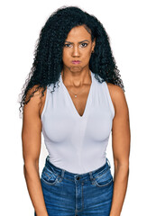 Middle age african american woman wearing casual style with sleeveless shirt puffing cheeks with funny face. mouth inflated with air, crazy expression.