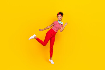 Fototapeta na wymiar Full size photo of funky young girl dance enjoy music favorite song wear trendy red striped clothes isolated on yellow color background
