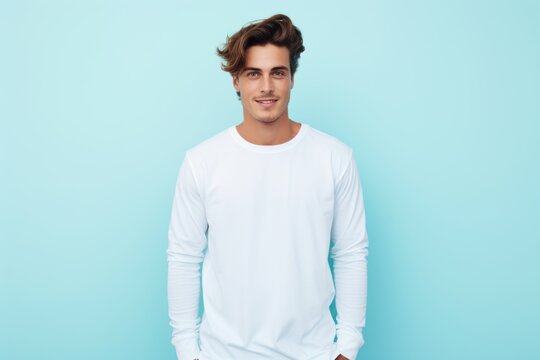 a photo of a handsome fit model guy with a blank white canvas long sleeve shirt. pastel blue wall background. Generative AI