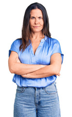 Young beautiful brunette woman wearing casual t-shirt skeptic and nervous, disapproving expression on face with crossed arms. negative person.