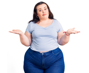 Young plus size woman wearing casual clothes clueless and confused expression with arms and hands raised. doubt concept.