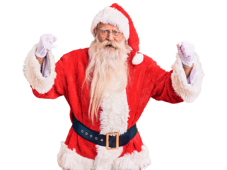 Old senior man with grey hair and long beard wearing traditional santa claus costume angry and mad raising fists frustrated and furious while shouting with anger. rage and aggressive concept.