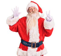 Old senior man with grey hair and long beard wearing traditional santa claus costume showing and pointing up with fingers number seven while smiling confident and happy.