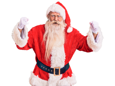 Old senior man with grey hair and long beard wearing traditional santa claus costume angry and mad raising fists frustrated and furious while shouting with anger. rage and aggressive concept.