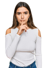 Young hispanic woman wearing casual clothes asking to be quiet with finger on lips. silence and secret concept.