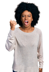 Young african american woman wearing casual clothes angry and mad raising fist frustrated and furious while shouting with anger. rage and aggressive concept.