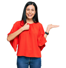 Beautiful young woman wearing casual clothes showing palm hand and doing ok gesture with thumbs up, smiling happy and cheerful
