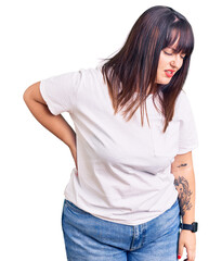 Fototapeta premium Young plus size woman wearing casual clothes suffering of backache, touching back with hand, muscular pain