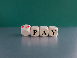 Concept words do not pay on cubes. Beautiful grey table green background. Business, financial crisis and do not pay concept. Copy space.