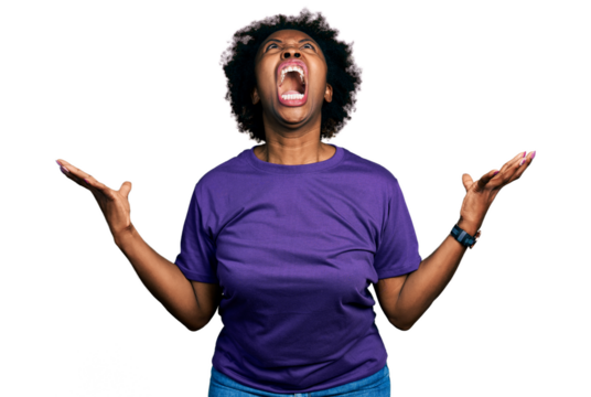 African american woman with afro hair wearing casual purple t shirt crazy and mad shouting and yelling with aggressive expression and arms raised. frustration concept.