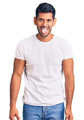 Fototapeta premium Young latin man wearing casual clothes sticking tongue out happy with funny expression. emotion concept.