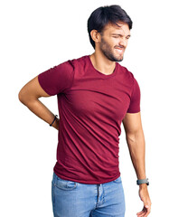 Handsome hispanic man wearing casual clothes suffering of backache, touching back with hand, muscular pain