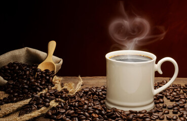 Black coffee or hot tea in a cappuccino espresso cup, breakfast food with coffee beans on a wooden table Isolated on a dark background, top view