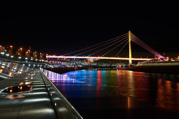 Beautiful view of the illuminated Bridge of Lovers over the Tura River at dusk, Tyumen, Russia