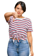 Fototapeta premium Beautiful young woman with short hair wearing casual clothes looking unhappy and angry showing rejection and negative with thumbs down gesture. bad expression.