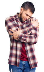 Young handsome man wearing casual shirt hugging oneself happy and positive, smiling confident. self love and self care